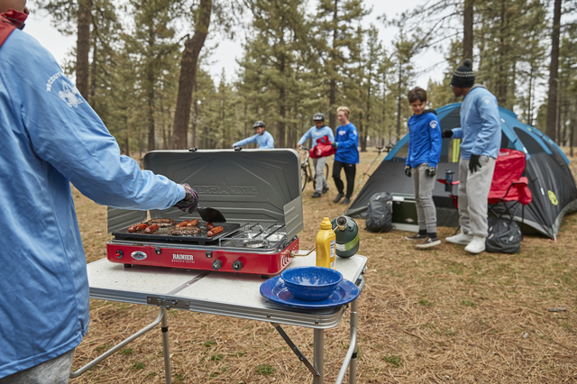 Campers cooking on stove and preparing to Mountain Bike