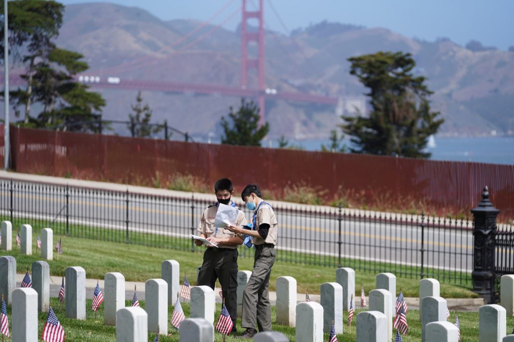 Scouts placing USA flags at grave markers
